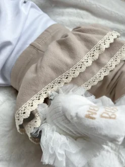 Jasnobeżowe getry z falbankami i koronką